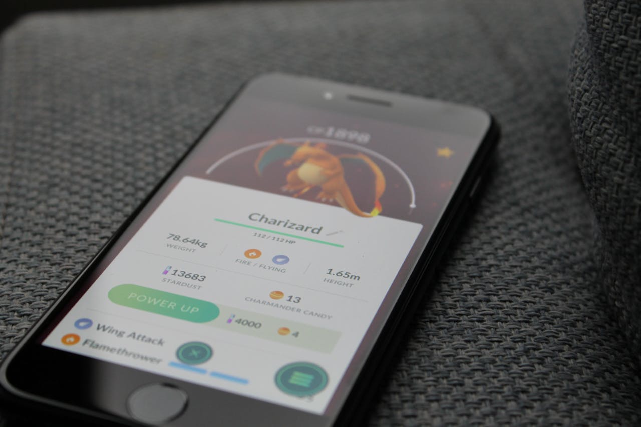 services-03 Smartphone displaying Pokémon GO screen with Charizard, highlighting gaming technology.